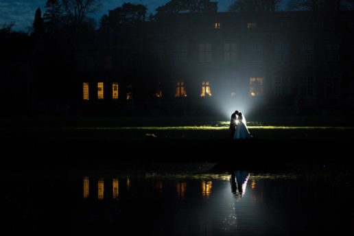 reflection of bride and groom in brympton house lake