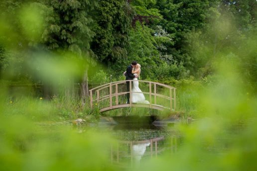 couple kissing on the bridge at aynhoe park wedding venue in oxfordshire
