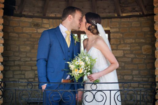 wedding couple kissing inside the Cotswold Stone Roundhouse at winkworth farm