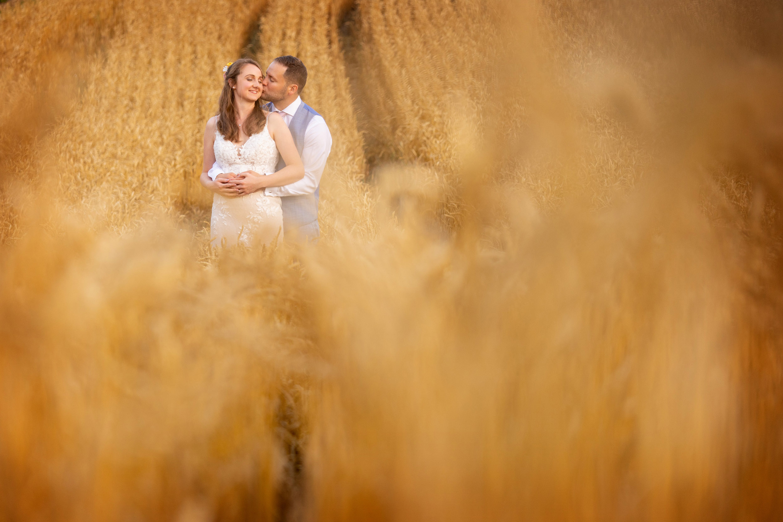 bride and groom kissing in the field at barn at upcote cotswolds