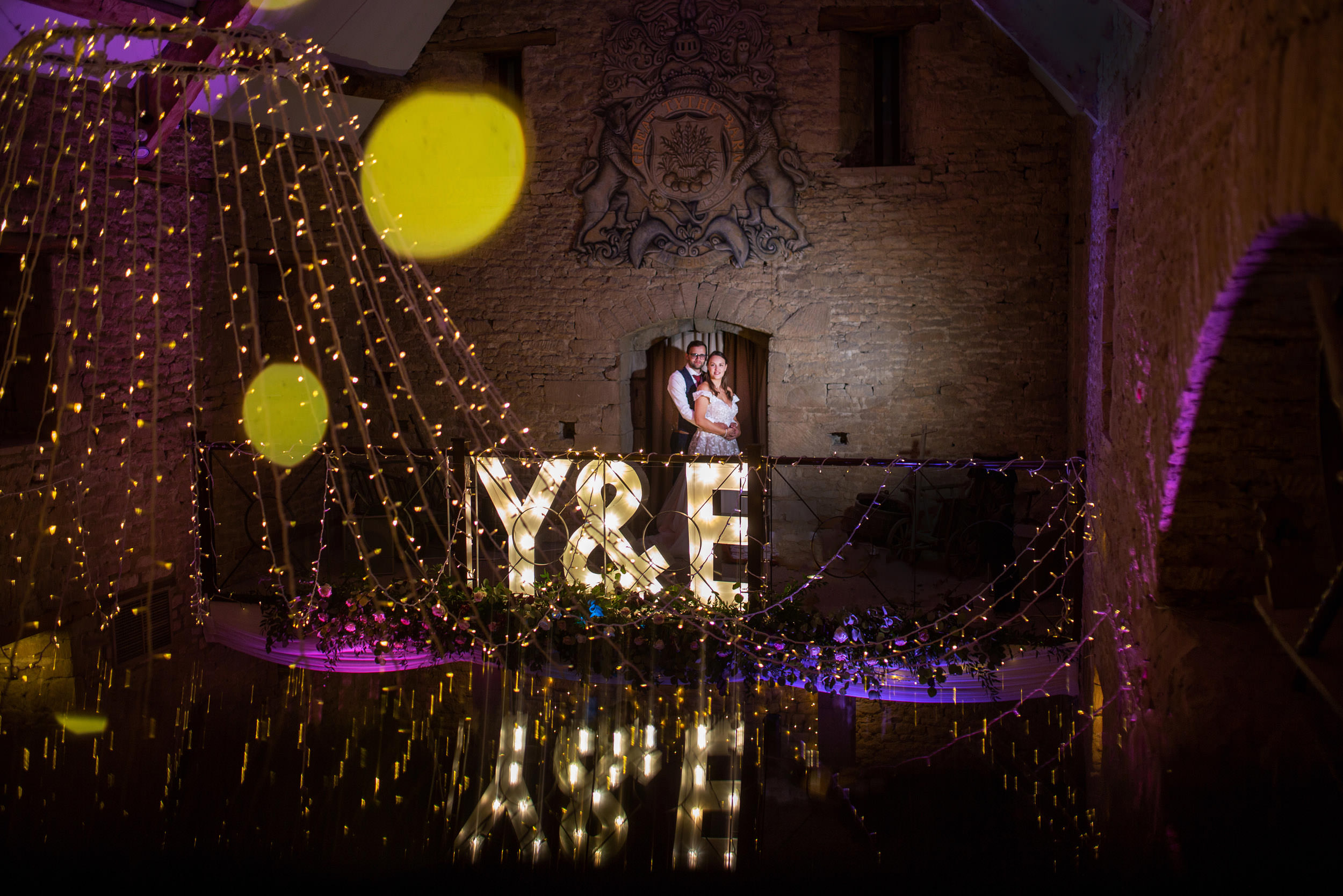 bride and groom at night on the balcony at the great tythe barn.The Great Tythe Barn Wedding Photography