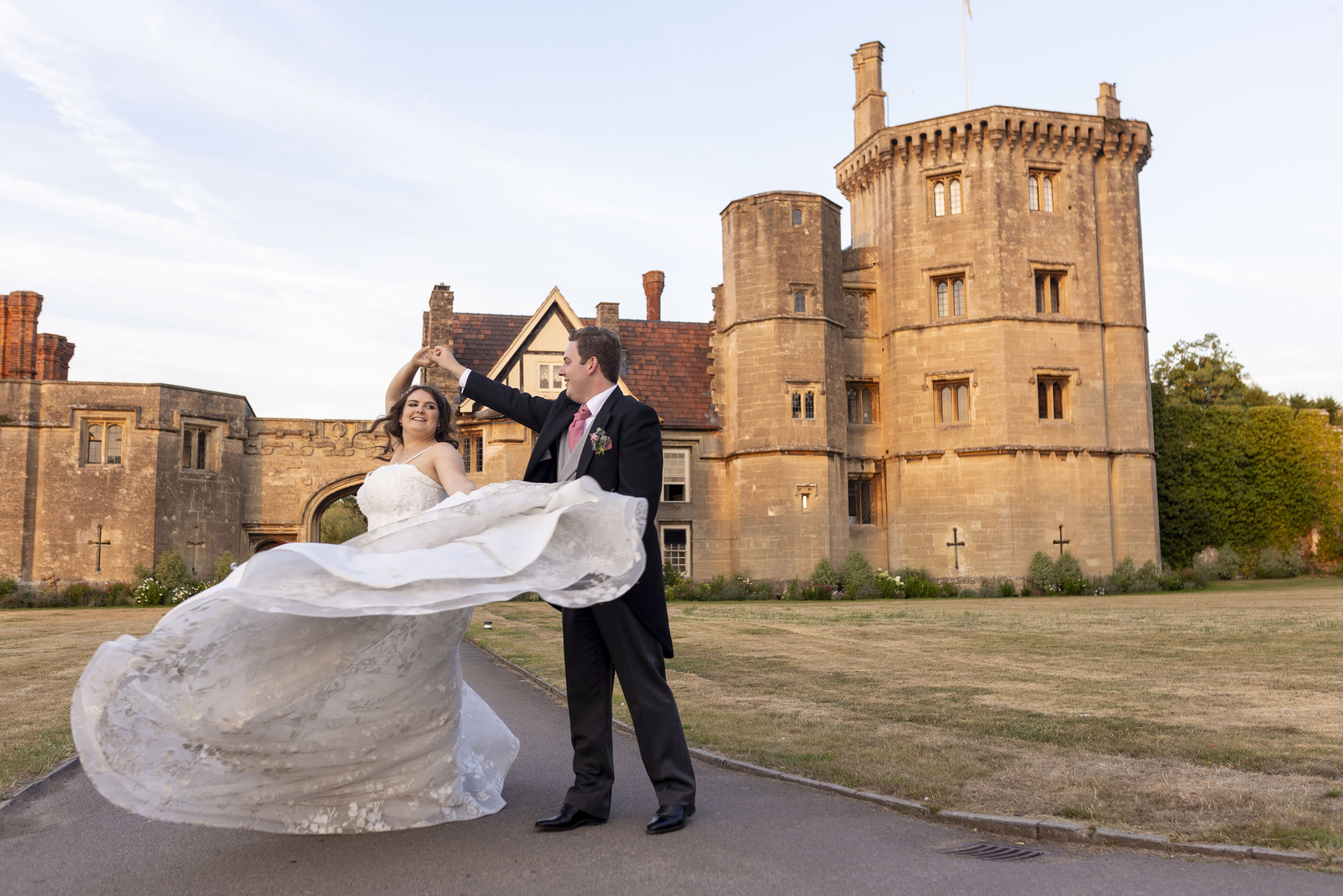 bride and groom dancing in front of thornbury castle