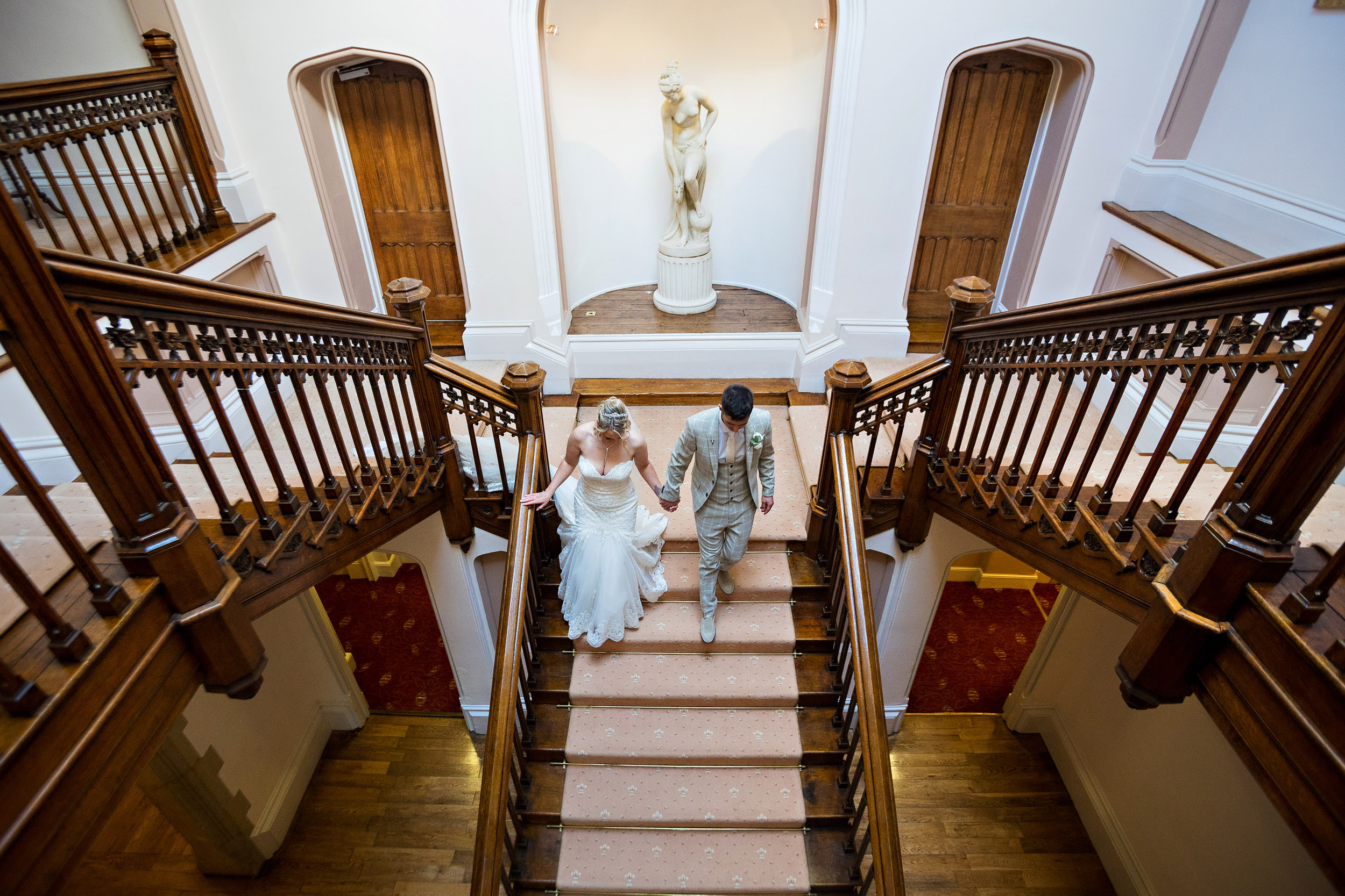 bride and groom walking down the stairs at st audries park