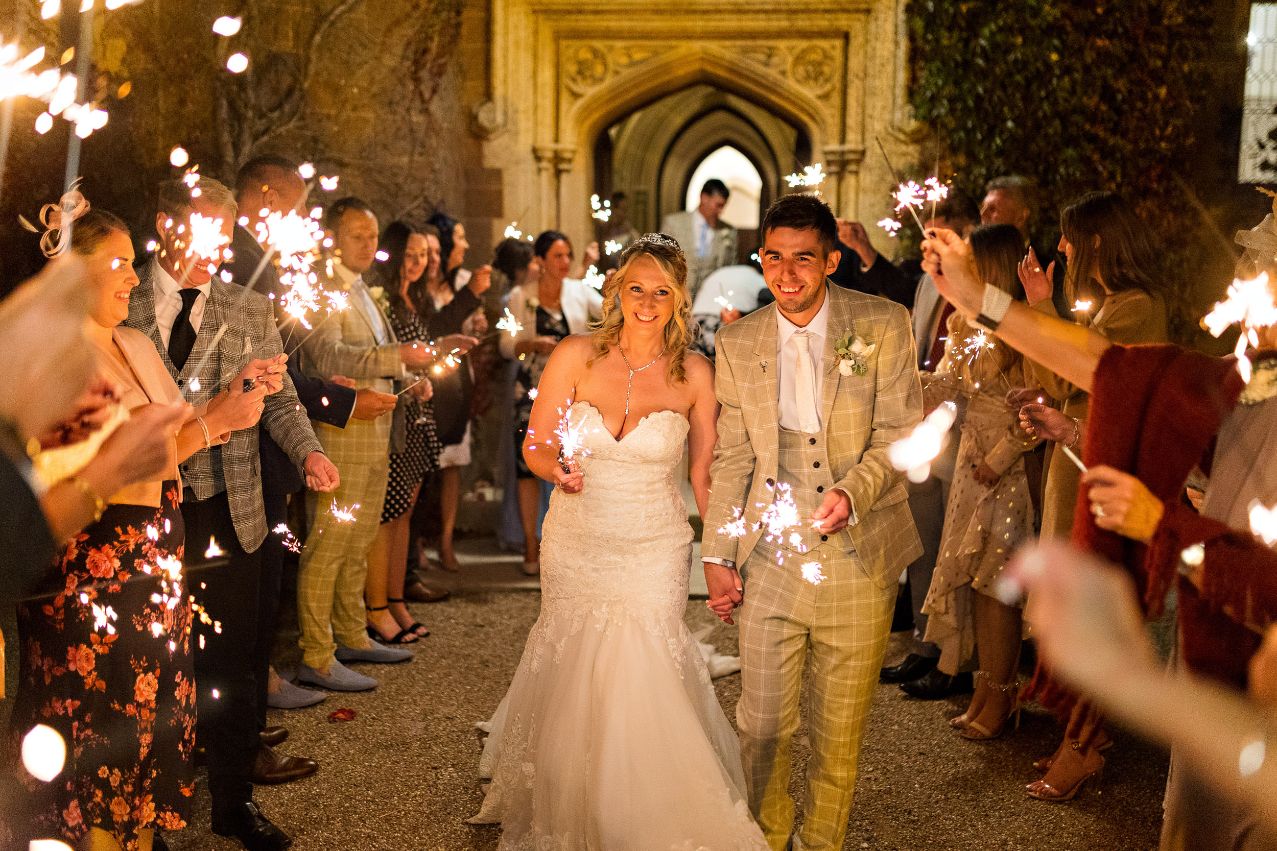 bride and groom walking with sparklers at st audries park
