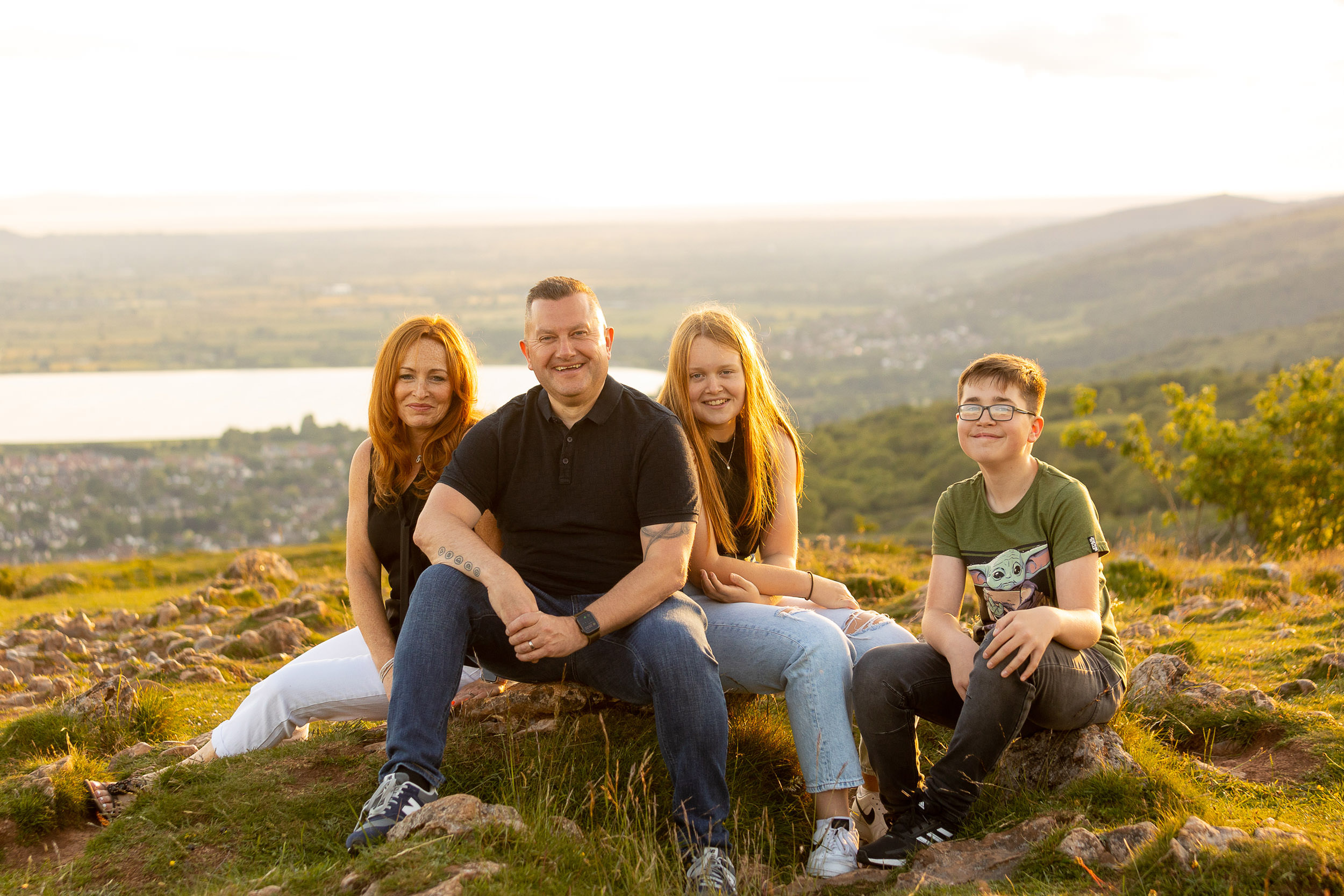 family sitting on the stone at sunset on the top of cheddar gorge