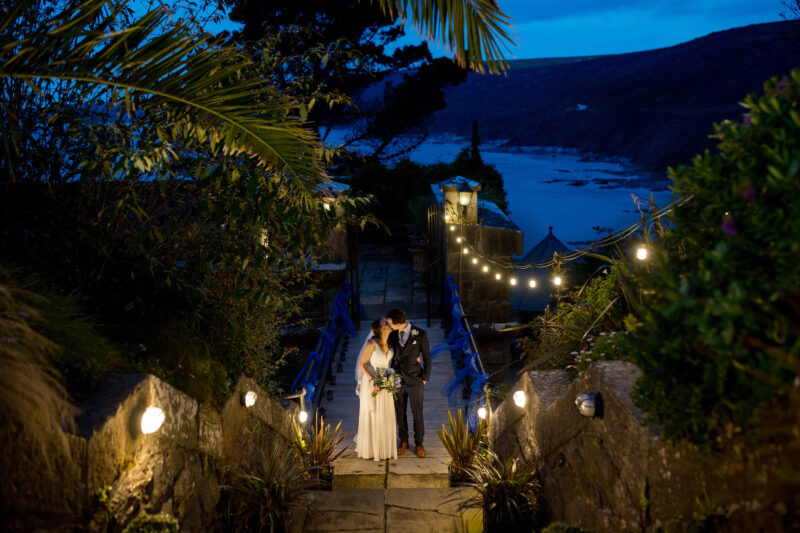 bride and groom kissing at night at polhawn fort in cornwall