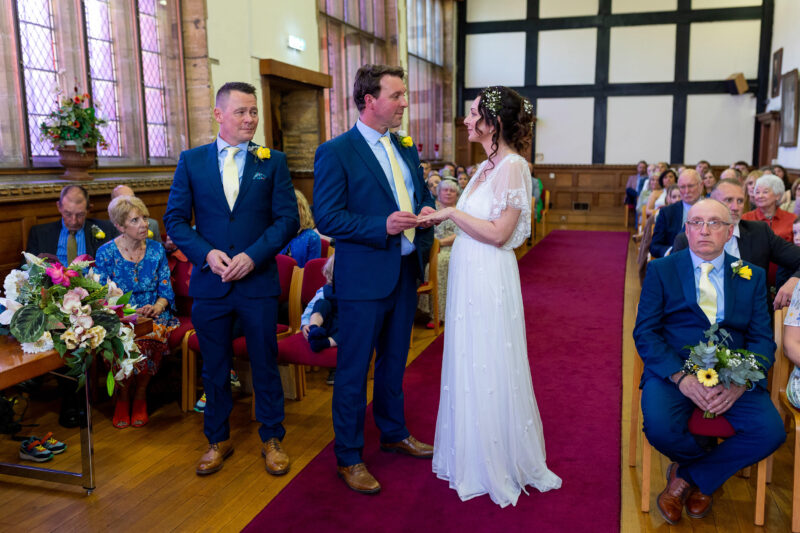 bride and groom exchanging wedding rings at Tudor Hall at Taunton registry office
