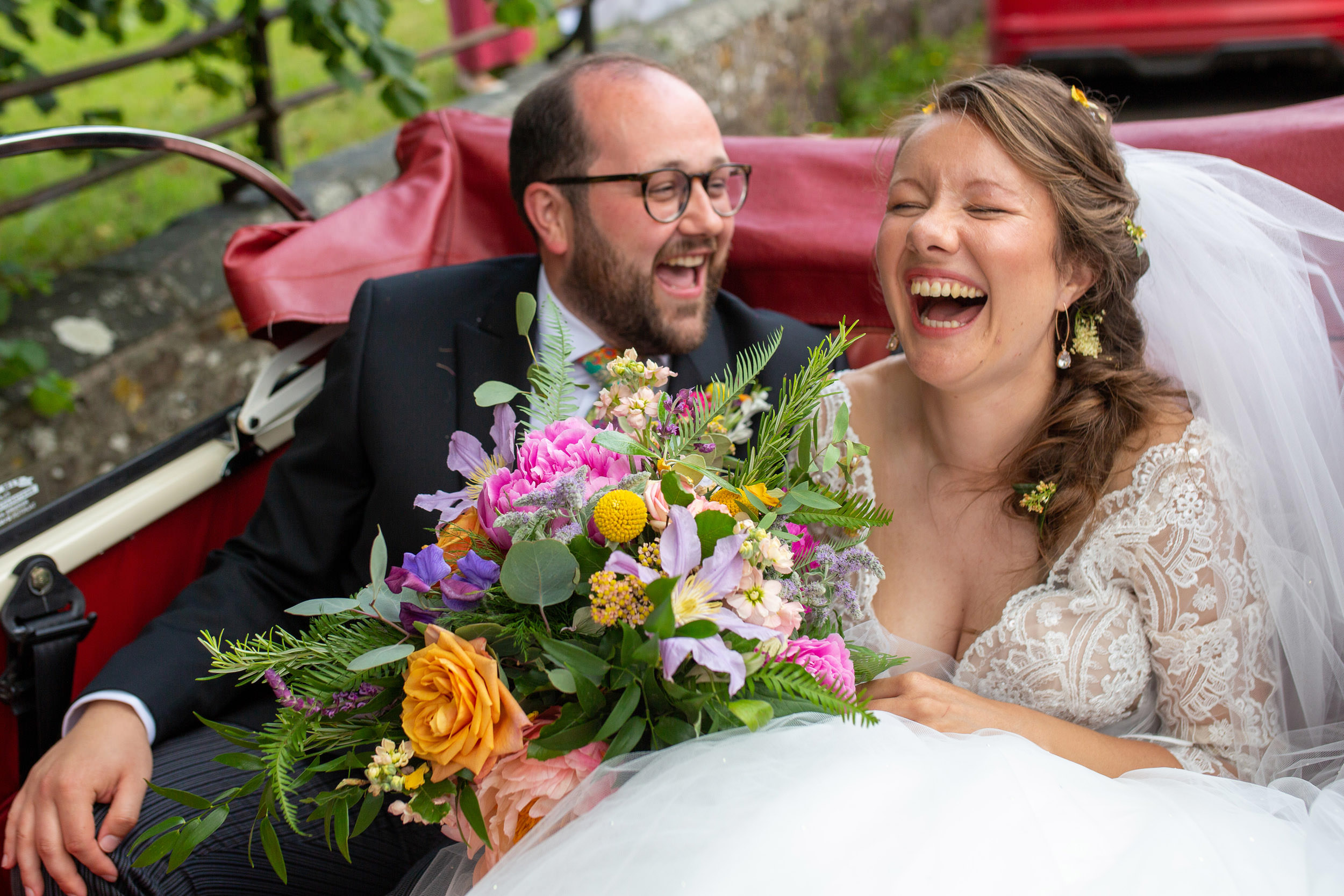 bride and groom laughing  in the wedding car